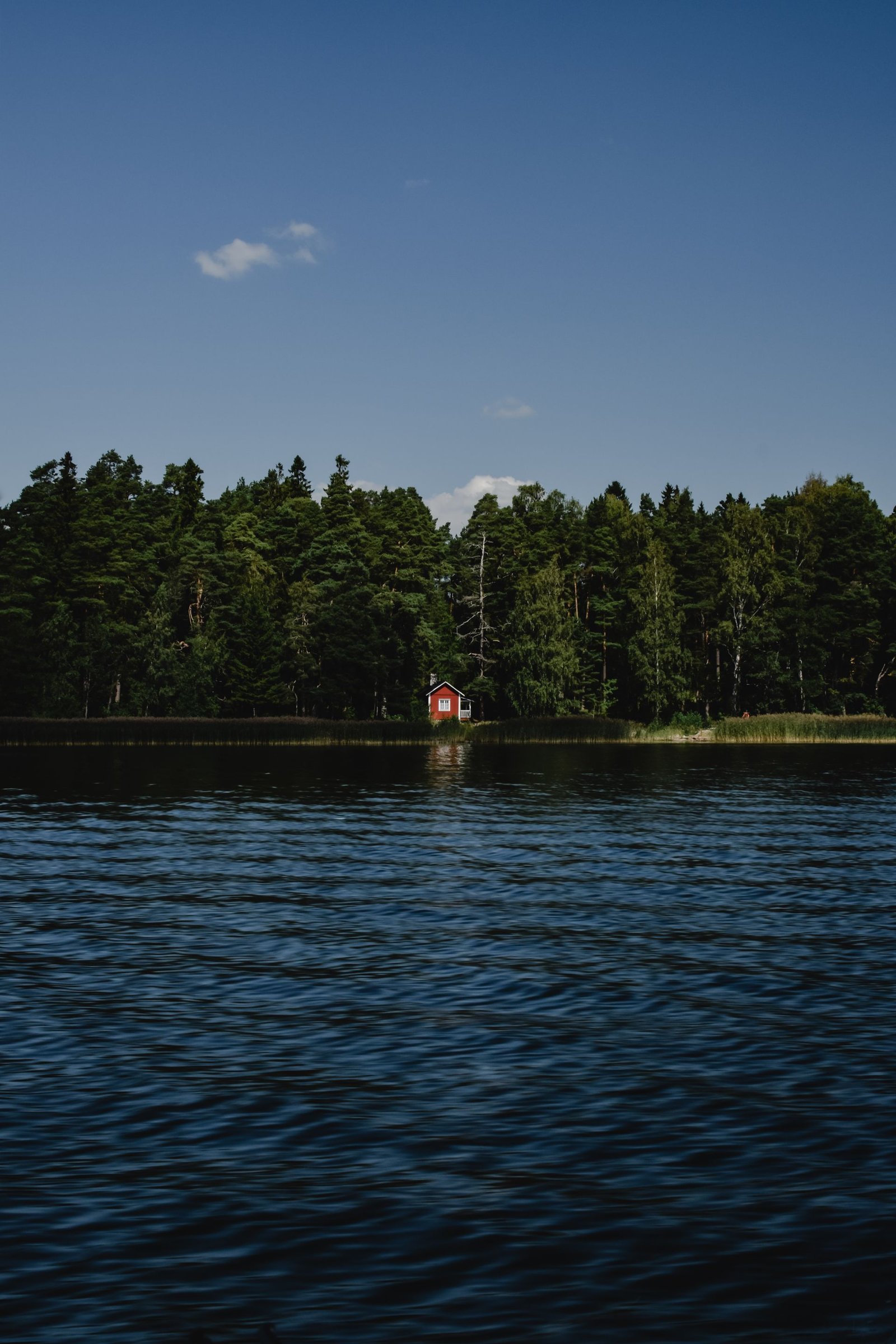 Punainen mökki suomalaisen järven rannalla